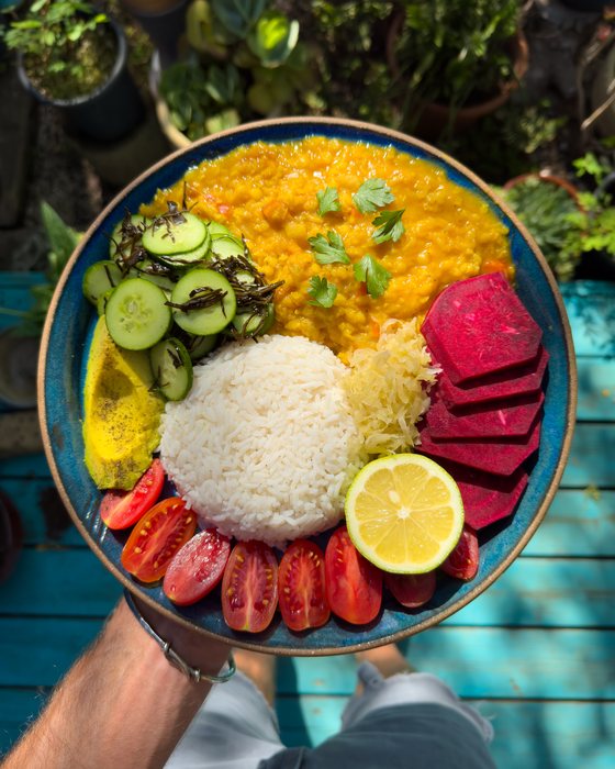 Tomato red lentil stew with rice, beetroot and fresh vegetables.